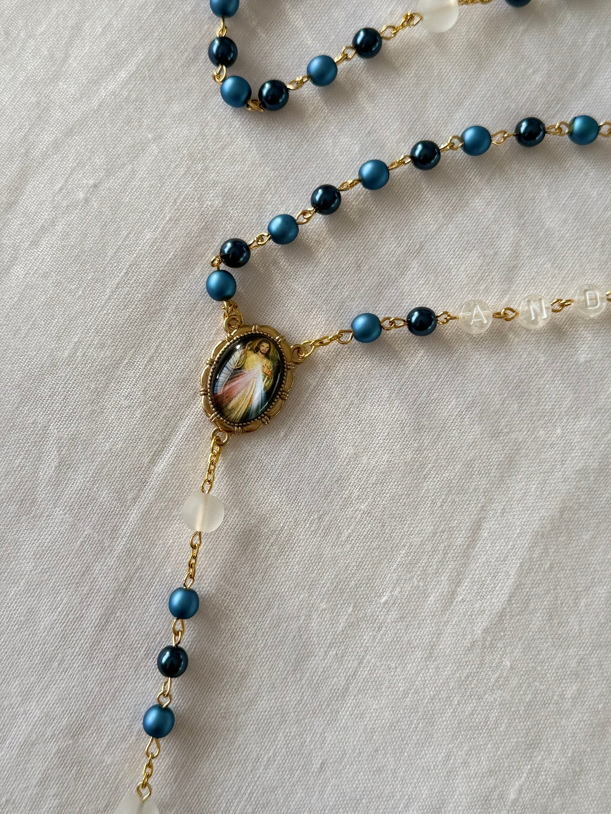 Necklace with blue beads and a decorative clasp on a light fabric background