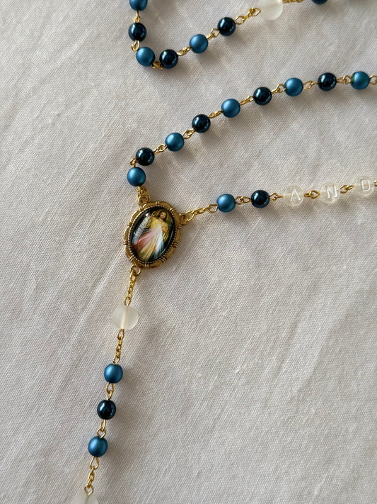 Necklace with blue beads and a decorative clasp on a light fabric background