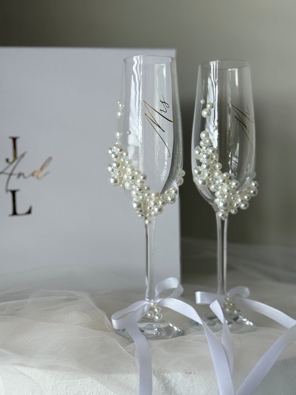 Personalised pearl champagne flute set with custom names and hand-applied pearl embellishments for weddings and engagements.