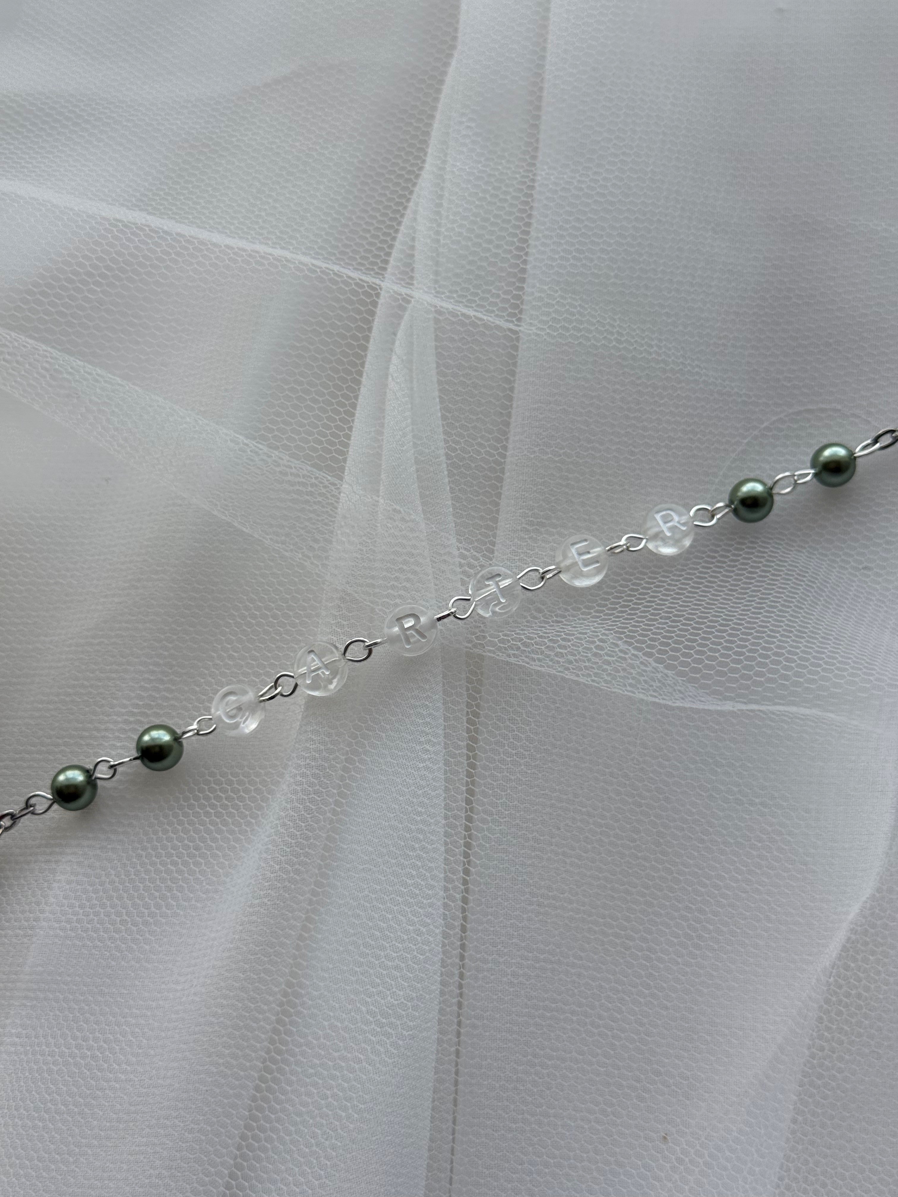 Close-up of soft sage green pearl beads on personalised rosary, elegant Catholic keepsake